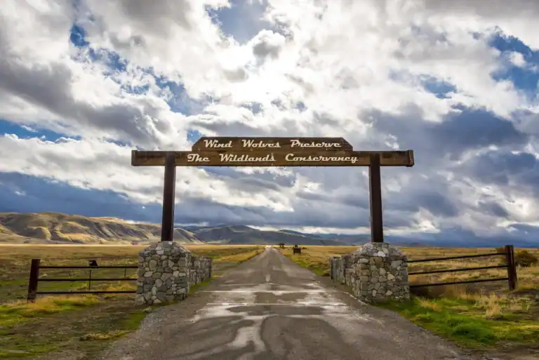 Entrance to Wind Wolves Preserve with scenic landscape and cloudy sky.