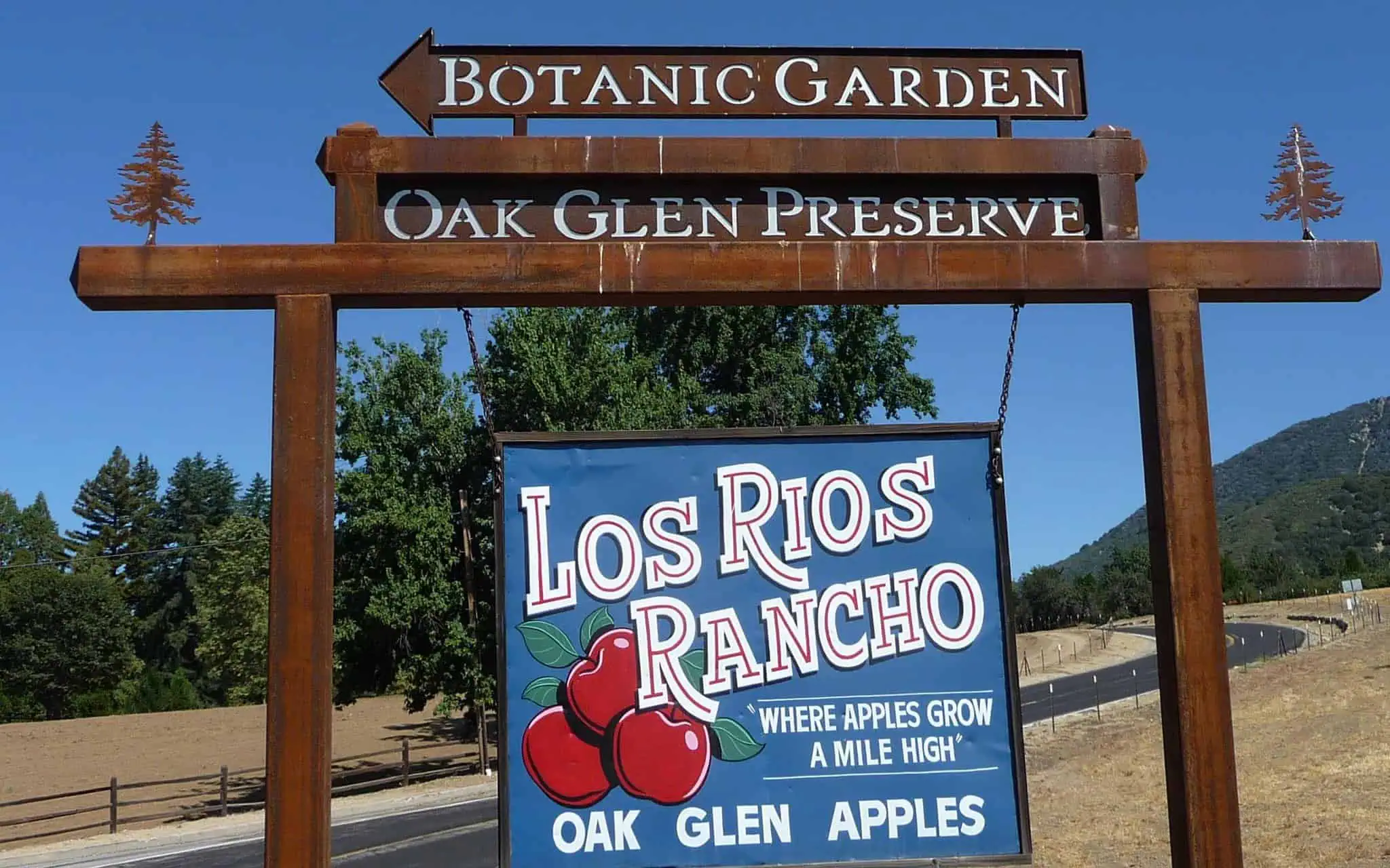 Sign for Los Rios Rancho with apple and cherry illustrations at Oak Glen Preserve.