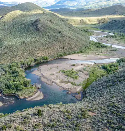 Beautiful river winding through green hills in a scenic natural landscape.