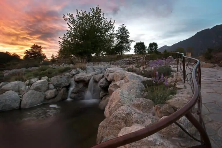 Sunset over a natural landscape with a small waterfall and rocky stream at The Wildlands Conservancy.