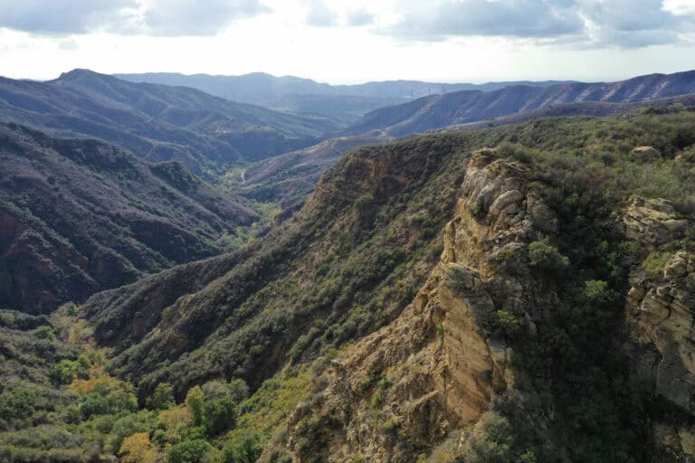 Scenic mountain landscape with lush green valleys and rugged cliffs.