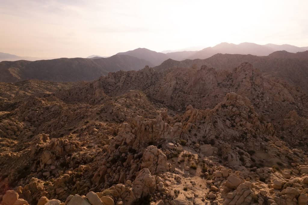 Rugged mountain terrain with rocky formations and distant mountain ranges.