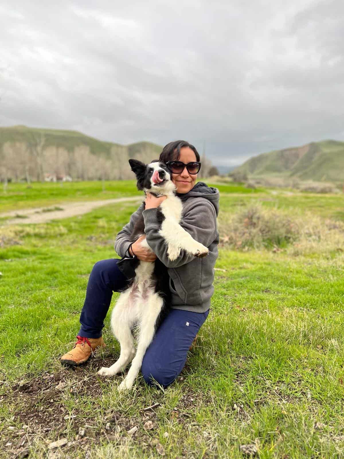 Woman with dog at Wind Wolves Preserve in scenic landscape.