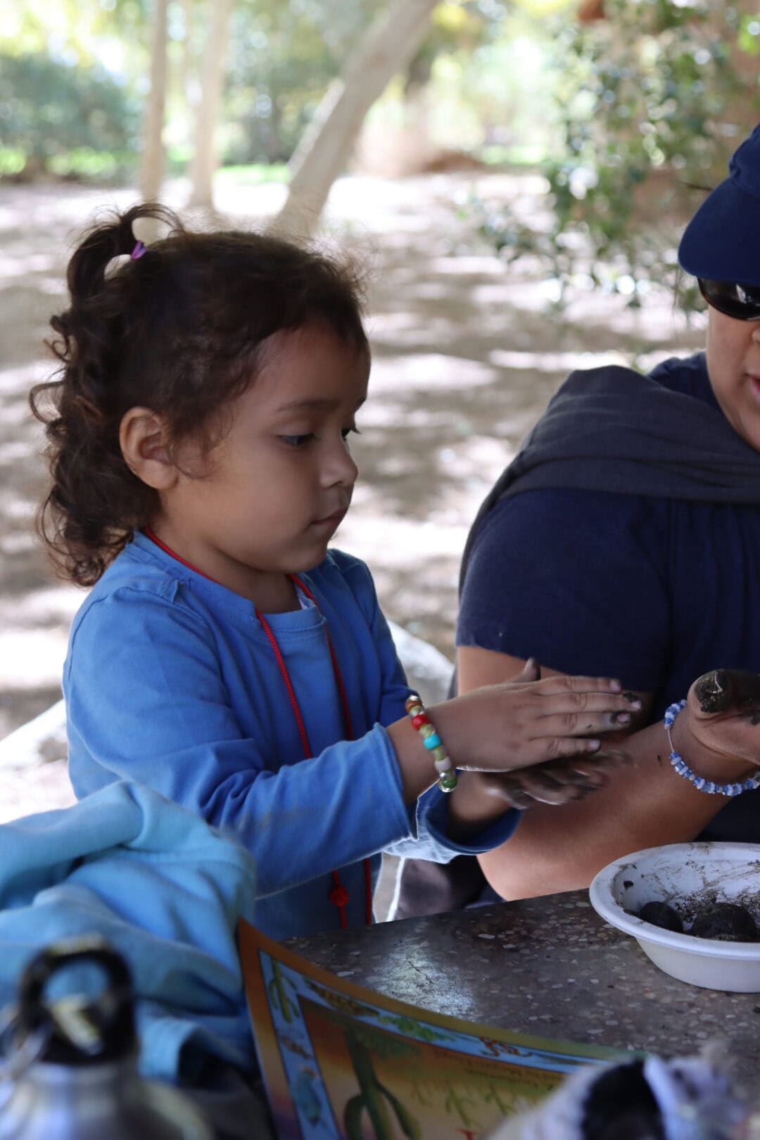 Children making seed bombs outdoors for environmental conservation.
