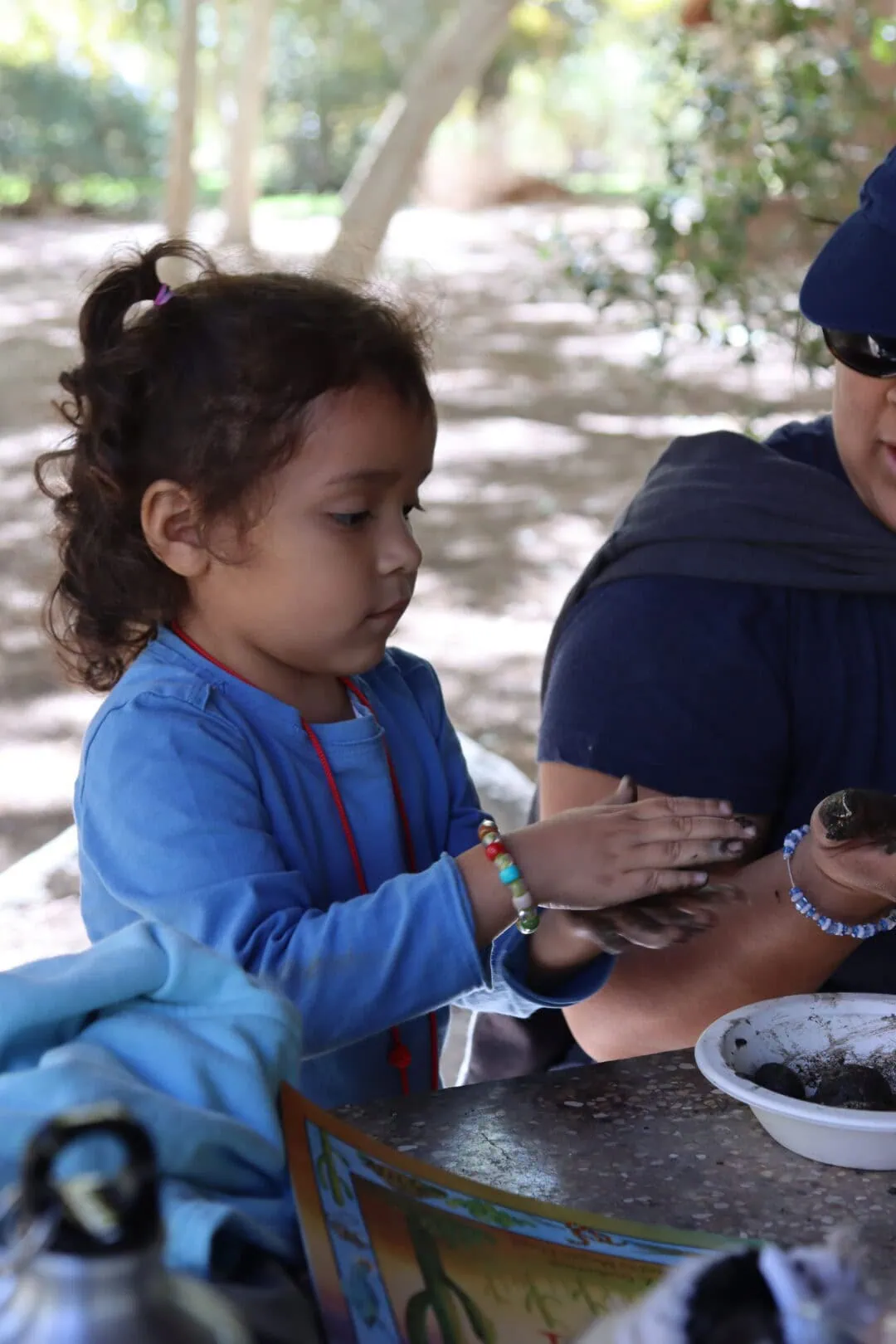 Children making seed bombs outdoors for environmental conservation.