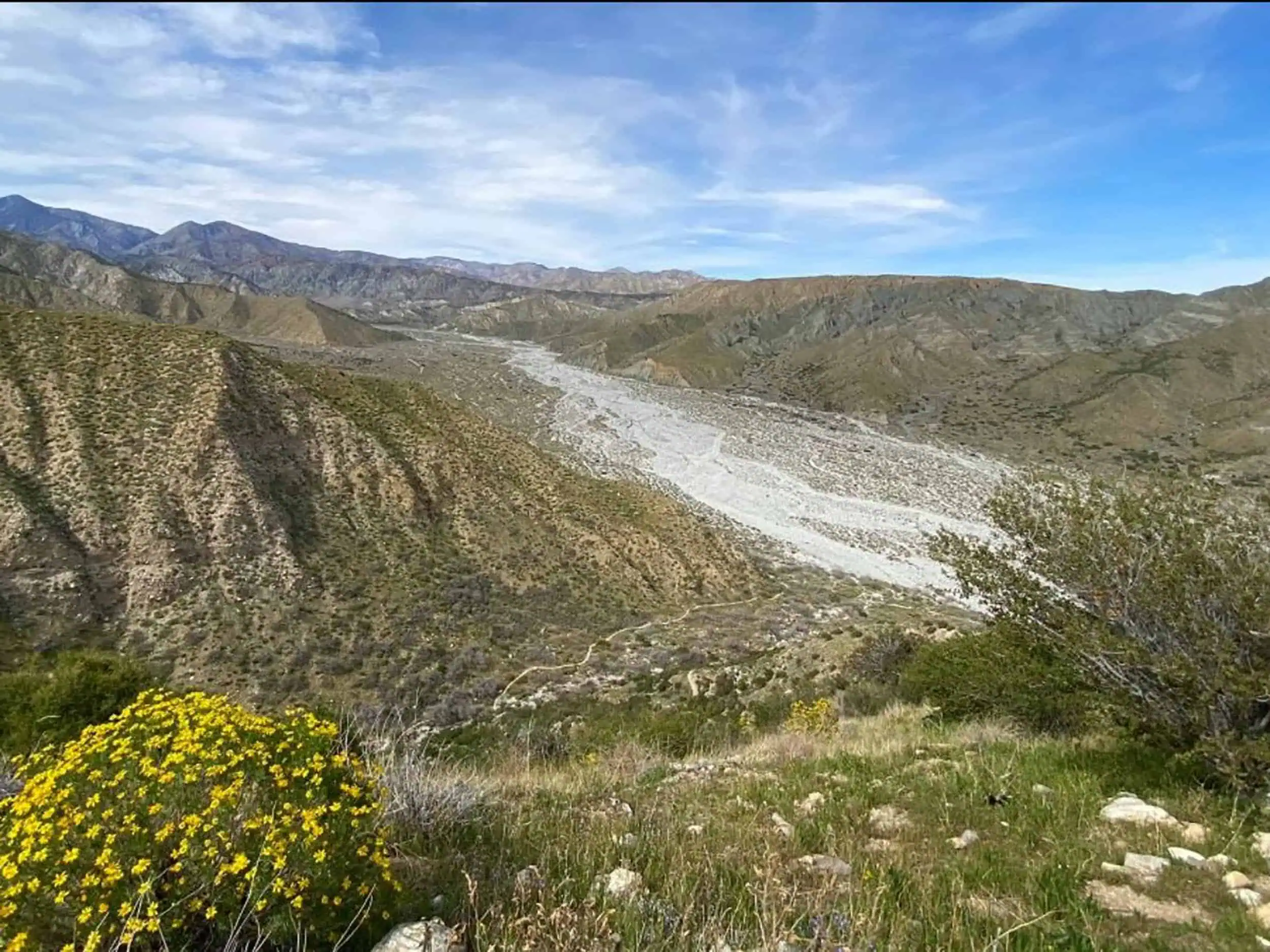 Mountain river flowing through a valley with mountains in the background.