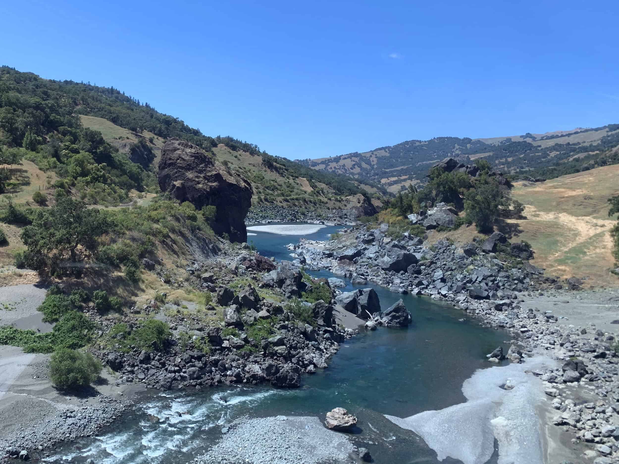 Scenic view of Eel River in the canyon with rocky banks and green hills.