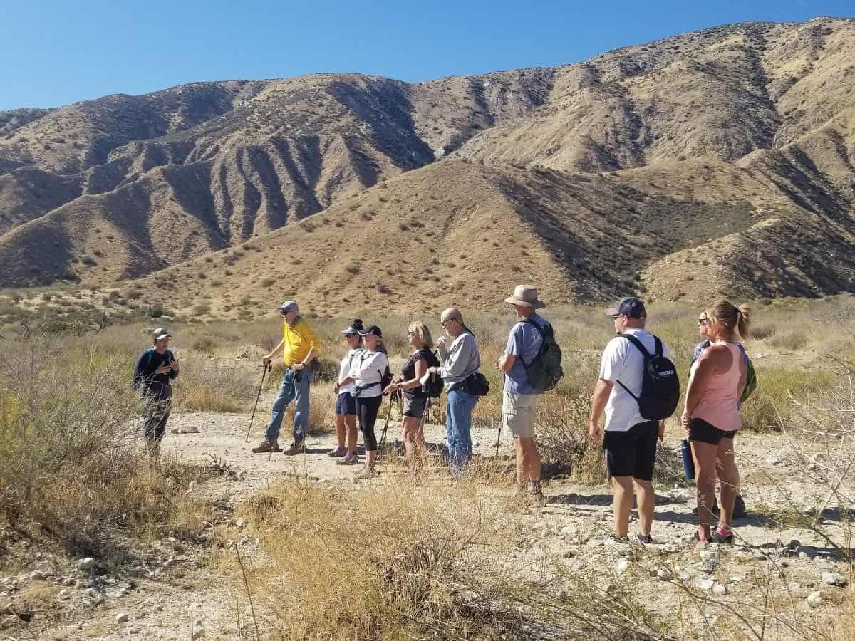 Group of people on a nature walk in desert mountains during Native American Heritage Month.